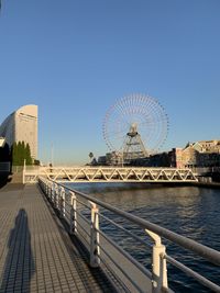 Ferris wheel in city against clear sky