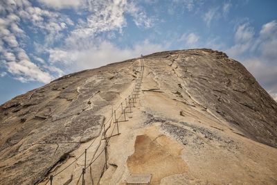 Low angle view of mountain against cloudy sky