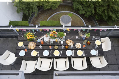 Directly above shot of food and drinks arranged on dining table in penthouse balcony