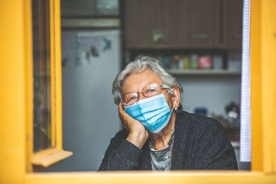 Portrait of senior woman wearing mask at home