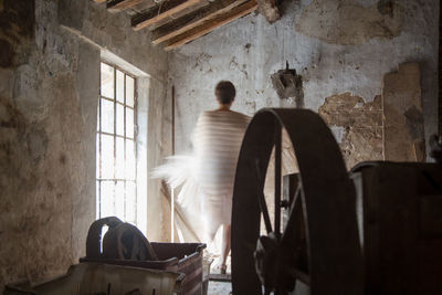 Rear view of man standing in abandoned building