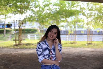 Portrait of smiling young woman standing outdoors
