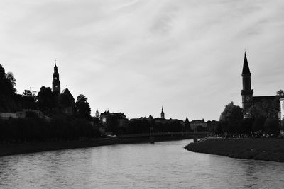 View of river by buildings against sky in city