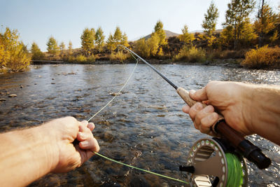 Cropped image of man fishing in lake