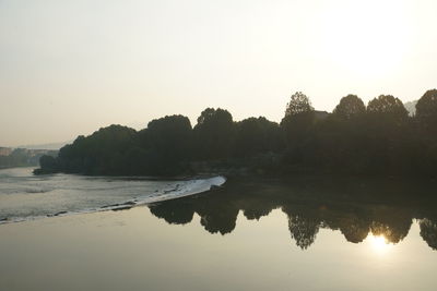 Scenic view of lake against clear sky at sunset