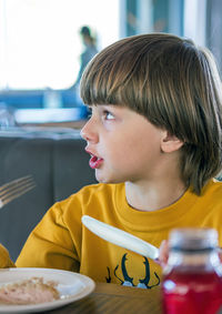 Close-up of boy looking away while sitting at cafe