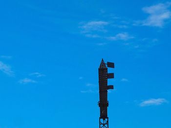 Low angle view of communications tower against blue sky