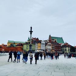 People walking on street against buildings in city