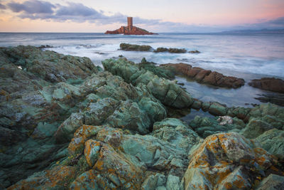 Scenic view of mediterranean sea with island against sky during sunset