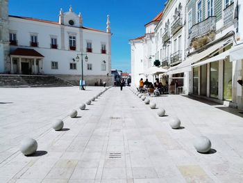 Footpath in town by church against clear sky