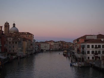 Boats in river with buildings in background