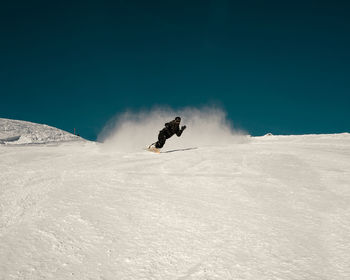 Person skiing on snowcapped mountain against sky