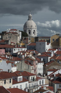 View of cityscape against cloudy sky