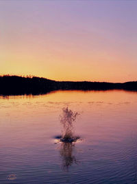 Scenic view of lake against sky at sunset