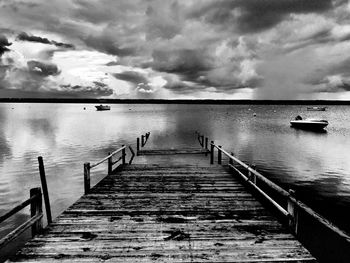 Pier over sea against cloudy sky