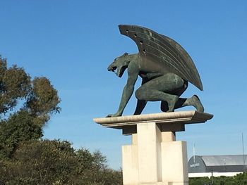Low angle view of statue against clear blue sky