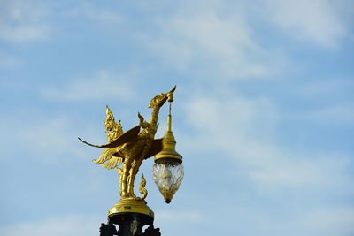 Low angle view of angel statue against sky