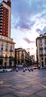 City street and buildings against cloudy sky