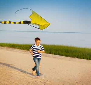 Full length of boy standing on beach