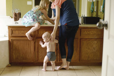 Mother with children in bathroom at home