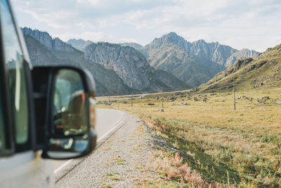 Parked car on the auto road against beautiful mountain landscape, chemalsky tract, altai