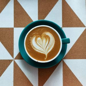 Coffee with latte art on textured background. teal coffee cups