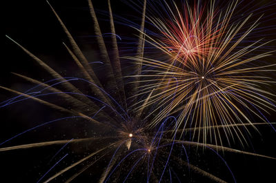 Low angle view of firework display at night