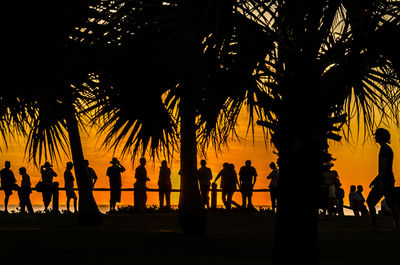 Silhouette people at beach during sunset