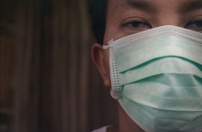Close-up portrait of a young woman covering face