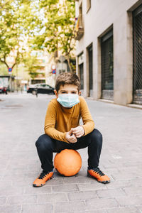 Little boy with a ball and protective mask. coronavirus concept.