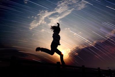 Low angle view of woman dancing against clear sky