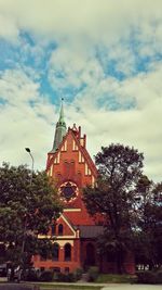 Low angle view of church against cloudy sky