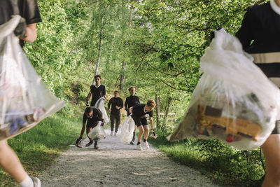 Volunteers plogging on footpath amidst plants