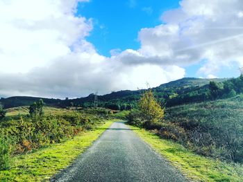 Empty road along landscape against sky