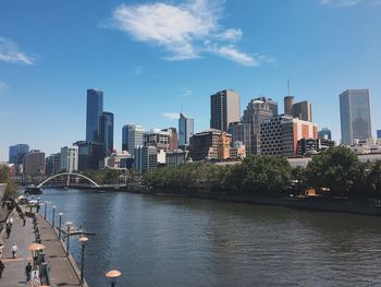City at waterfront against blue sky