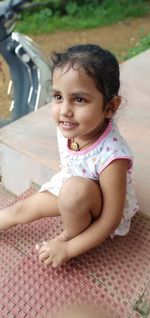 Portrait of a smiling girl sitting outdoors