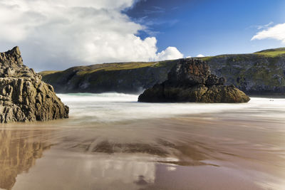 Scenic view of rocks in sea against sky