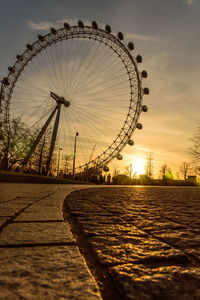 Ferris wheel against sky at sunset