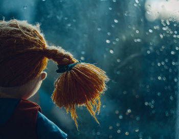 Close-up of doll by glass window