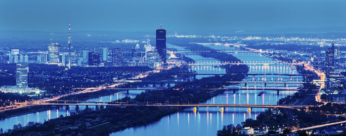 High angle view of illuminated cityscape against sky at night