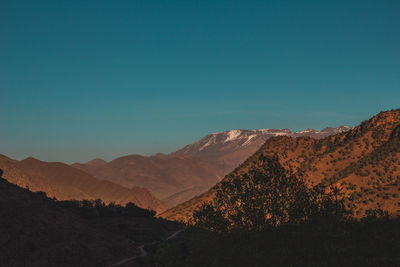 Scenic view of mountains against clear blue sky