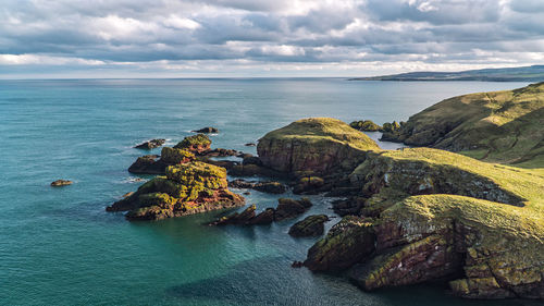 Rock formation in sea against sky