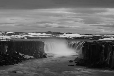 Scenic view of waterfall against sky