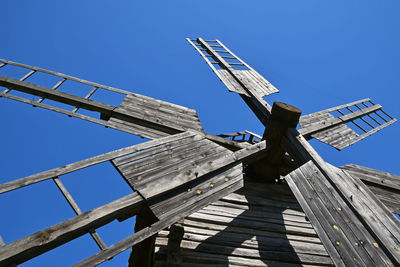 Low angle view of crane against clear blue sky