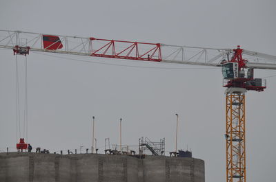 Low angle view of crane against sky