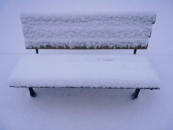High angle view of snow covered bench