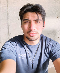 Portrait of young man against wall