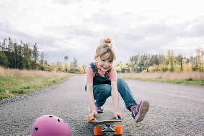 Young girl playing on a skateboard looking happy