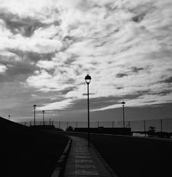 Empty road against cloudy sky