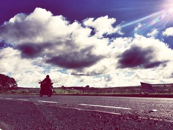 Empty road against cloudy sky